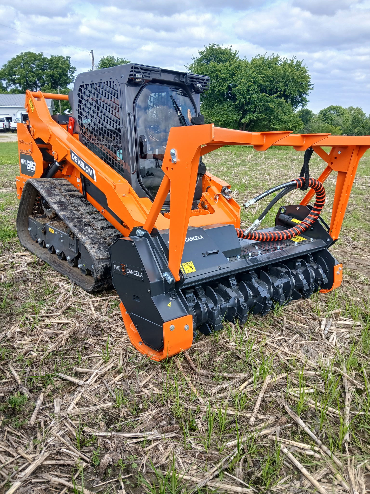 Develon DTL35 compact track loader with forestry mulcher head on a harvested field